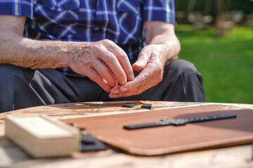 Elderly man playing a board game outdoors, close-up on hands