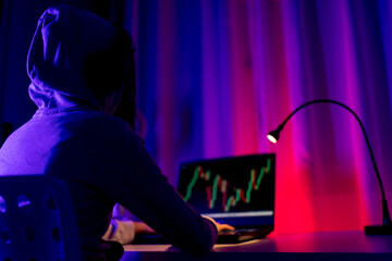 Unrecognizable young male trader analyzing stock charts on computer