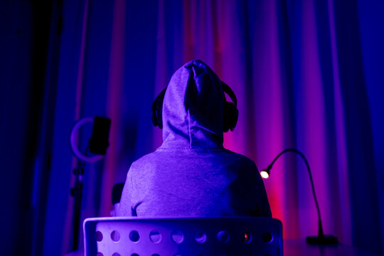 Back view of unrecognizable boy trading at computer