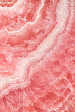 Textured close-up of pink rhodochrosite stone surface