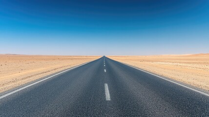 Endless desert road under clear blue sky
