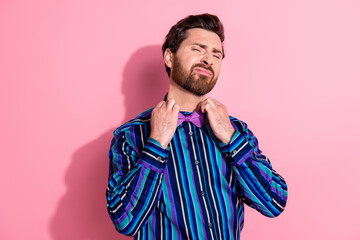 Photo of handsome elegant man preparing holiday wearing stylish bowtie isolated on pink color...