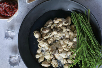 Fresh oysters served with seafood sauce, fried red onion and Acacia leaves on ice in black plate. Healthy sea food