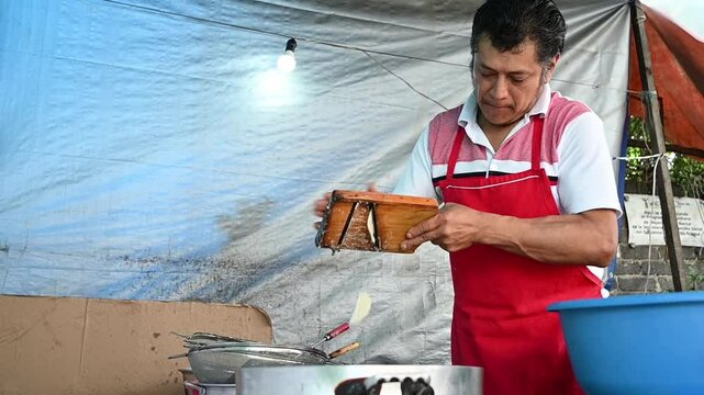 Mexican man making chips fries at Mexican food stand