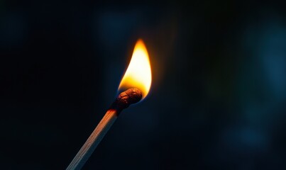 A match igniting with a bright flame against a dark background in a moody atmosphere at night