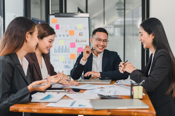 Professional team collaborating in modern office, discussing charts and graphs with enthusiasm. Their engagement reflects teamwork and productivity