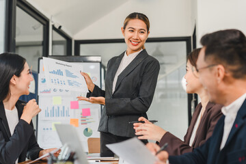 professional woman presents marketing reports to team in modern office. atmosphere is collaborative...