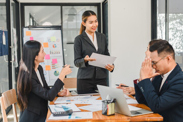 business meeting with woman presenting to colleagues, showcasing charts and reports. team appears engaged and focused on discussion
