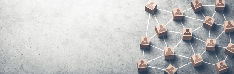 Wooden Blocks With Human Icon Connected Together On Grey Concrete Background - Teamwork And...