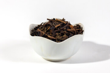 Dried tea leaves isolated on white background. Tea is a caffeinated beverage, an infusion made by steeping the dried leaves, leaf buds, or leaf stalks of the Camellia sinensis plant in hot water.