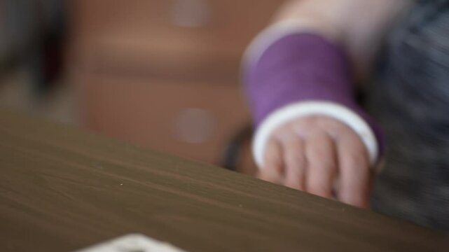 A closeup of an elderly persons hand holding a playing card, with a blurred background of another hand holding cards, suggesting a game in progress.
