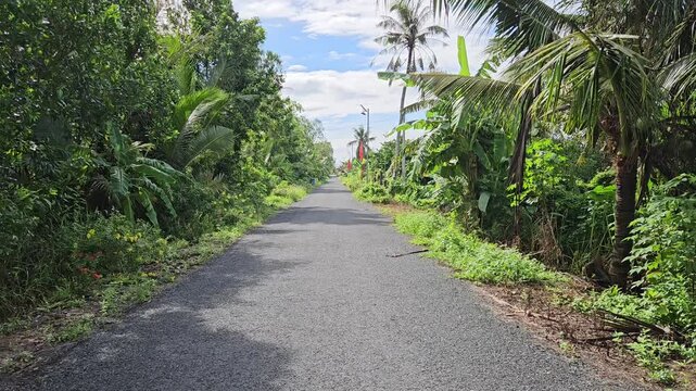 Panning shot of village street in the countryside at Mang Thit district, Vinh Long province, Mekong Delta Vietnam in the morning.