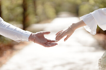 A couple in love touches each other with their hands. Love story of a young couple in love. Wedding rings on ring fingers. Concept of a marriage proposal. Starting a family.