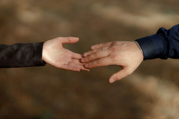 A couple in love touches each other with their hands. Love story of a young couple in love. Wedding rings on ring fingers. Concept of a marriage proposal. Starting a family.