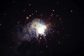 A bright flash of light and a sheaf of sparks in a cloud of smoke. Miniature Universe. Design...