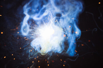 A bright flash of light and a sheaf of sparks in a cloud of smoke. Miniature Universe. Design...