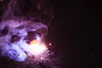 A bright flash of light and a sheaf of sparks in a cloud of smoke. Miniature Universe. Design...