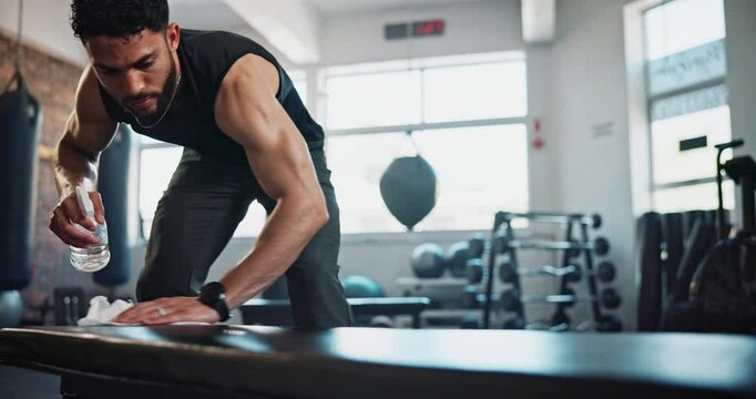 Cleaning, spray and bench with man in gym for disinfection, sanitary and bacteria. Health, wellness and germs with person and chemical with sports equipment for safety, virus and disease prevention