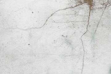 White texture of a concrete wall with natural relief and damage in the form of chips and scratches. Fragment of an old stone surface with a crack. Dark rough surface with a place for an inscription