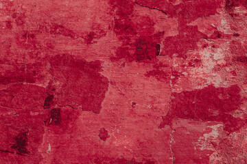 Obraz premium Red texture of a concrete wall with natural relief and damage in the form of chips and scratches. Fragment of an old stone surface with a crack. Dark rough surface with a place for an inscription