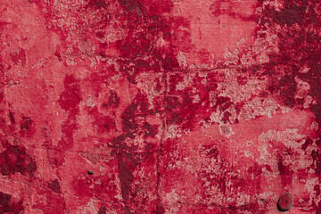 Red texture of a concrete wall with natural relief and damage in the form of chips and scratches. Fragment of an old stone surface with a crack. Dark rough surface with a place for an inscription
