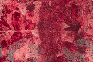 Red texture of a concrete wall with natural relief and damage in the form of chips and scratches. Fragment of an old stone surface with a crack. Dark rough surface with a place for an inscription