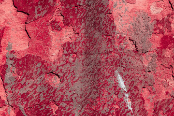 Fototapeta premium Red texture of a concrete wall with natural relief and damage in the form of chips and scratches. Fragment of an old stone surface with a crack. Dark rough surface with a place for an inscription