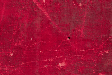 Red texture of a concrete wall with natural relief and damage in the form of chips and scratches. Fragment of an old stone surface with a crack. Dark rough surface with a place for an inscription
