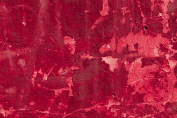 Red texture of a concrete wall with natural relief and damage in the form of chips and scratches. Fragment of an old stone surface with a crack. Dark rough surface with a place for an inscription