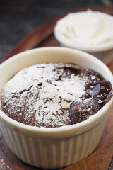 Delicious Chocolate Lava Cake with Powdered Sugar and Whipped Cream on Wooden Plate