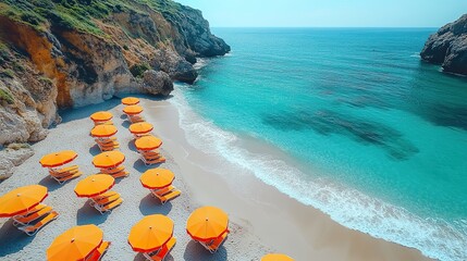 Obraz premium Aerial view of a beach with umbrellas and lounge chairs, perfect for vacations or romantic getaways.