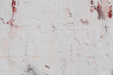 White texture of a concrete wall with natural relief and damage in the form of chips and scratches. Fragment of an old stone surface with a crack. Dark rough surface with a place for text.