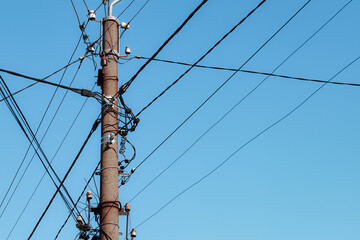 Overhead power lines. Telephone cable. Internet communications. An old post with a bunch of wires. Earth Day. Energy saving concept. The concept of saving electricity bills.
