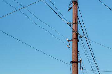 Overhead power lines. Telephone cable. Internet communications. An old post with a bunch of wires. Earth Day. Energy saving concept. The concept of saving electricity bills.