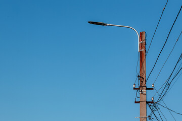 Overhead power lines. Telephone cable. Internet communications. An old post with a bunch of wires....
