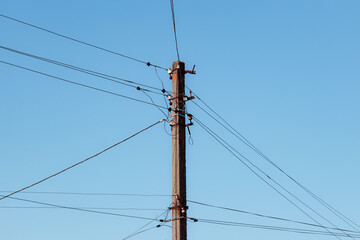 Overhead power lines. Telephone cable. Internet communications. An old post with a bunch of wires. Earth Day. Energy saving concept. The concept of saving electricity bills.