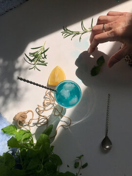 A woman's hand with lemon and blue curasao drink. View from above 