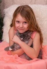 A girl is holding a beautiful cat in her arms. A child and a pet, a pet.