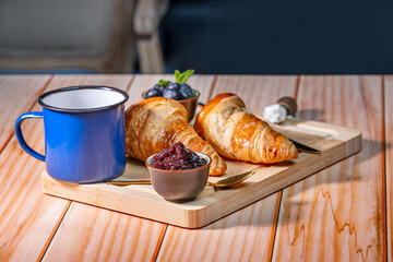 French Toast: Croissants are dipped in a mixture of eggs and milk, then cooked and served with blueberries and a maple sauce
