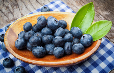 Blueberries in wooden bowls on wooden table