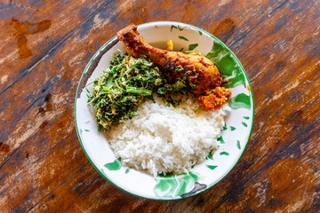 Indonesian dish. Rice with urap-urap (indonesian salad with chili, grated coconut and other spice) and roasted chicken