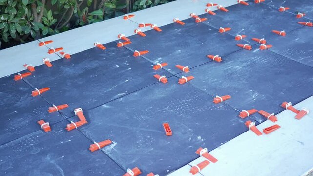 The process of installing dark tiles using spacers on a designated surface area effectively