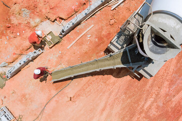 Overhead view of construction zone where fresh concrete is being applied to form foundation, using...