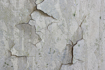 Peeling paint on the wall. Old concrete wall with cracked flaking paint. Weathered rough painted...