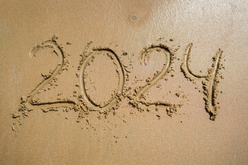 The Year 2024 Getting Written in Beautiful Sand at the Sunny Beachside Shoreline