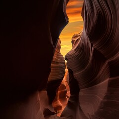 Deep red canyon glowing under a fiery orange sunset 