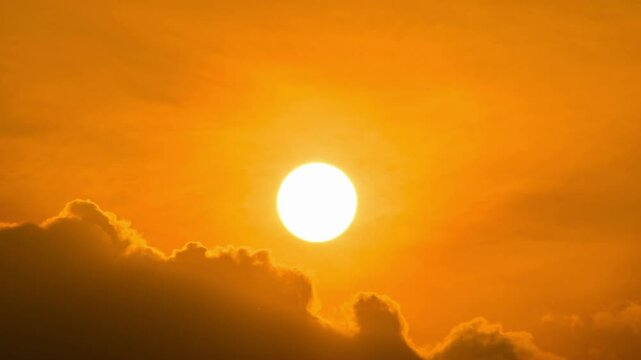 Time lapse of dramatic sunrise with orange sky in a cloudy day.