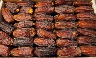 Dried Arabian dates are packed together in the box. Closeup
