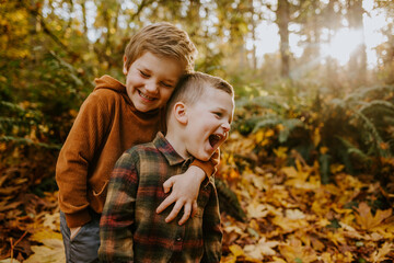 Brothers laughing together in an autumn forest