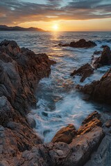 Obraz premium Sunset over ocean with rocks